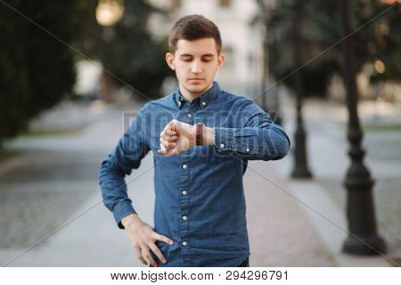 Handsome Business Man Look At The Watch In The City. Man Ajust The Exact Time On The Watch
