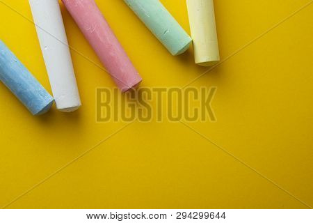 Abstract Colorful Chalks Over Yellow Background With Copy Space. Education Template. Creative Childh