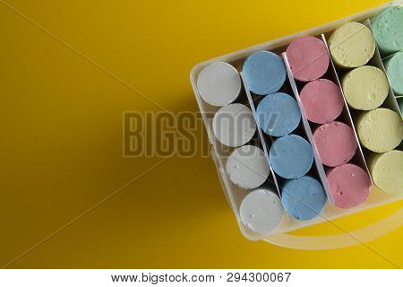 Abstract Colorful Chalks Over Yellow Background With Copy Space. Education Template. Creative Childh