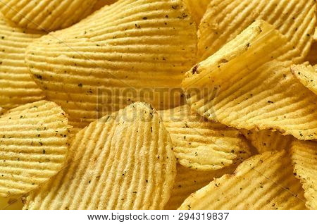 Background Of Juicy Corrugated Rounded Potato Chips Close-up