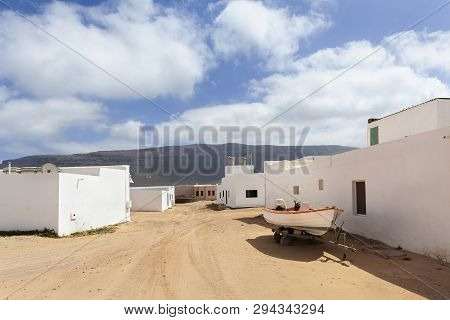 Empty Street With Sand And White Houses And A Trailer With Boat In Caleta De Sebo On The Island La G