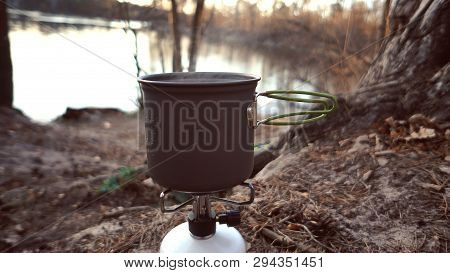 Close-up Of A Gas Burner, On Which A Kettle With A Lid Stands, Boils Water, Steam, Cooking In Outdoo