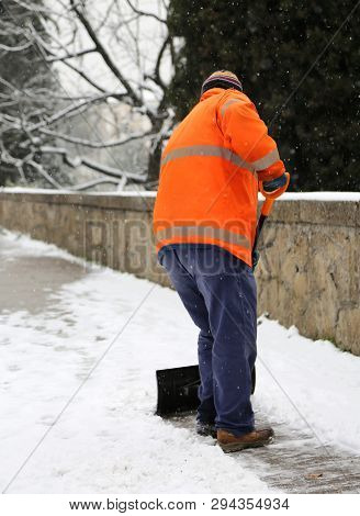 Snow Spreader With High Visibility Jacket Shovels The Sidewalk In Winter