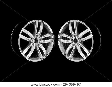 Pair Of Modern Aluminium Car Wheels In Dramatic Light. Mirrored Photo. Isolated.