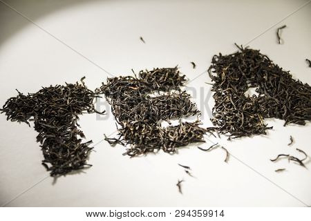 Inscription Tea From Black Tea Leaves On A White Background