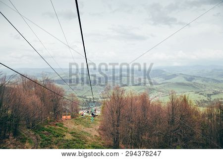 A View From A Cablecar, Cableway At Mountains Surrounded By Forest Going Down To The Meadow