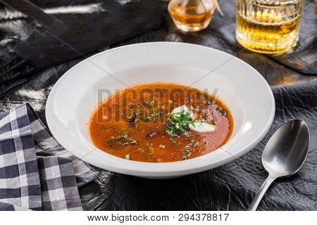 Red Beetroot Soup Borshch With Beef And Sour Cream On Black Table Side View