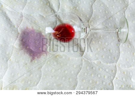 Wine Glass Spilled On Bed. Dropped Wineglass On White Bed Sheet. Pink Wet Stain. Unlucky, Unfortunat