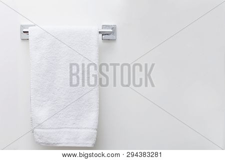 Modern Bathroom Towel Dryer On White Wall Background With Copy Space