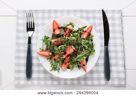 Healthy Organic Diet Salad With Arugula, Strawberries And Sesame In White Plate On Grey Napkin On A 