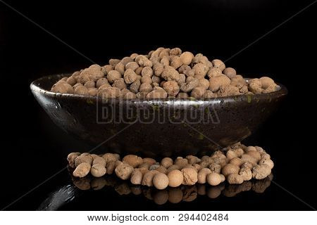 Lot Of Whole Brown Clay Pebbles (leca) On Grey Ceramic Plate Isolated On Black Glass