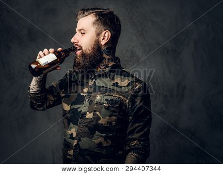 Stylish Bearded Hipster Guy In Military Shirt Enjoys The Taste Of Craft Beer. Studio Photo Against A