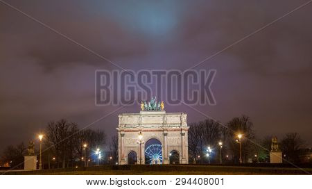 Paris, France - August 04, 2006: Beautiful view of the Arc de Triomphe du Carrousel in the evening against the backdrop of street lamps.