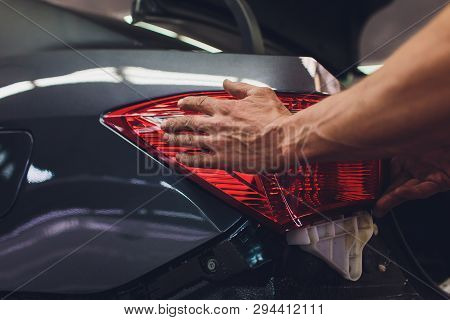 Mechanic Matching Automobile Headlight Lamp To Damaged Car At Repair Service Station.