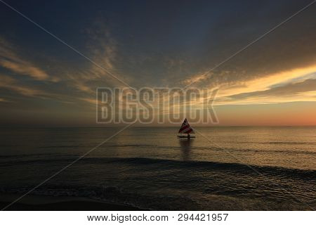 Captiva Island, Florida 08-05-2015 Small Sailboat In Partial Silhouette Against The Setting Sun In T