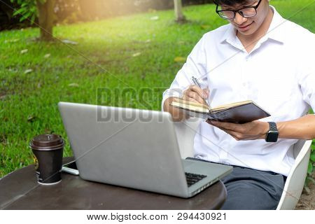 Young Buseness Man Work On The Table With His Laptop And Coffee In Garden Outdoor Loaction
