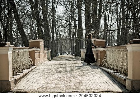 Lonely Girl On The Old Bridge. Early Spring, Bare Trees. Photo Toned