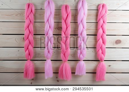 Kanekalon Hangs On A Wooden Background Of Pink, Fuchsia Red In Different Shades Similar