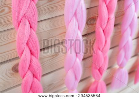 Kanekalon Hangs On A Wooden Background Of Pink, Fuchsia Red In Different Shades Similar