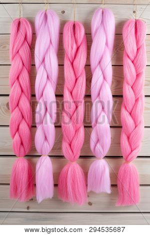 Kanekalon Hangs On A Wooden Background Of Pink, Fuchsia Red In Different Shades Similar