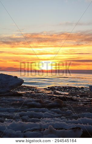 Beautiful Orange And Yellow Spring Sunset Over Ice Water And Melting Snow On Lake Huron In Kincardin