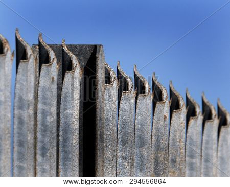 Galvanized Steel Security Fence With Sharp Top To Prevent Unauthorised Access. Some Corrosion Showin