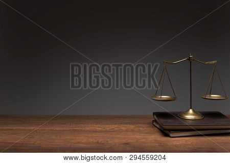 Gold Brass Balance Scale Placed On The Vintage Books And Wood Table With Gray Background, Legal Law 