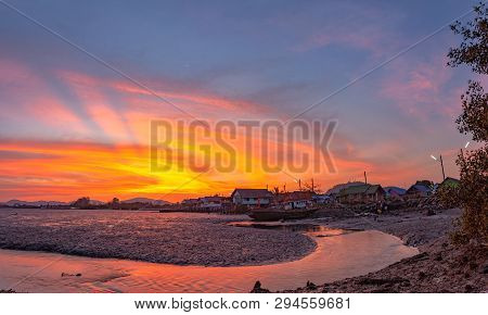 stunning sunset at fishing village in Phuket.during low tide will has a small canal beside fishing v