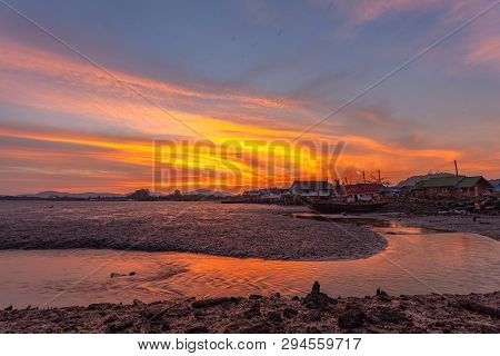 stunning sunset at fishing village in Phuket.during low tide will has a small canal beside fishing v