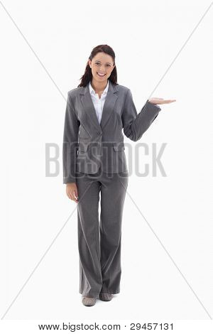 Businesswoman smiling and presenting a product against white background
