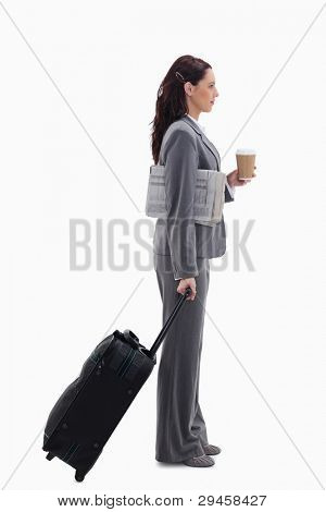 Profile of a businesswoman with a suitcase, a newspaper and a coffee against white background