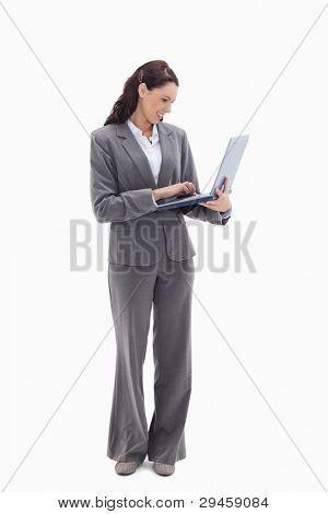 Businesswoman smiling while watching her laptop against white background