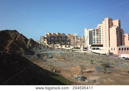 Dibba Al-Fujairah, Fujairah, UAE - April 4, 2019: Dry mountain landscape and back side of hotel Fairmont Fujairah