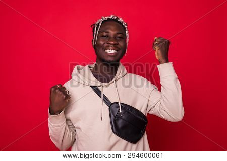 Young African Man Celebratin Sign Isolated On Red Background
