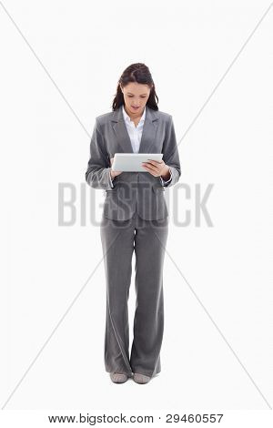 Businesswoman writing on a touch pad against white background
