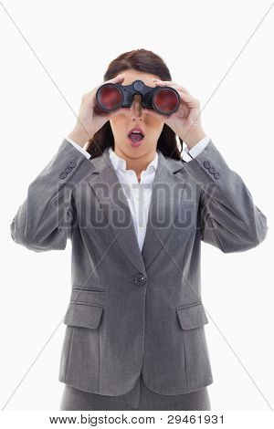 Close-up of a surprised businesswoman looking through binoculars against white background