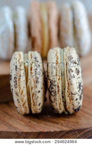 Two Cookies And Cream Macarons Standing Upright With Three Macarons Behind In The Background.