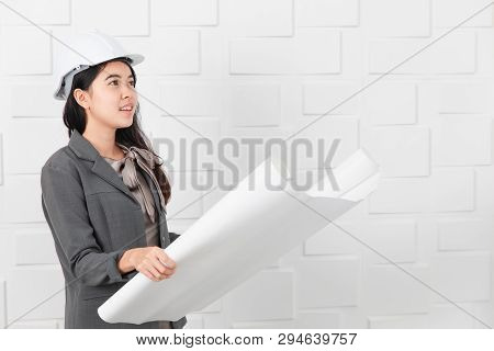 Shot Of Young Beautiful Asian Architect In Business Casual, Wearing Yellow Hardhat Holding And Reche