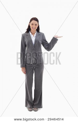 Smiling businesswoman and presenting a product against white background
