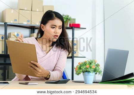 Shot Of Young And Beautiful Asian Business Lady In Casual Fashion Dress, Rechecking Purchase Order L