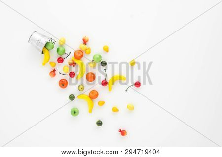 A Scattering Of Many Small Different Fruits On A White Background. Mini Copy Of A Metal Bucket. The 
