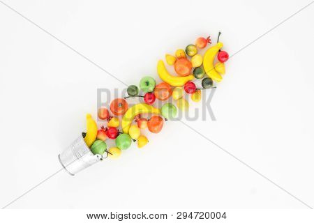 A Scattering Of Many Small Different Fruits On A White Background. Mini Copy Of A Metal Bucket. The 