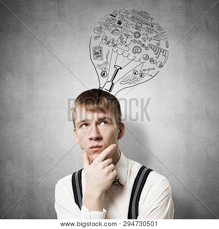 Redhead Student Thinking About Some Problem. Clever Boy On Background Of Grey Wall With Idea Lightbu