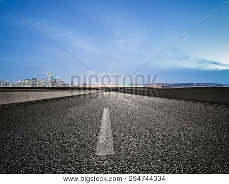 empty highway road with seattle skyline background at night.