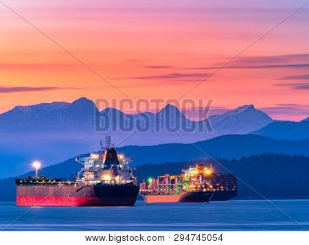 freighters stop at the bay of vancouver at sunset.