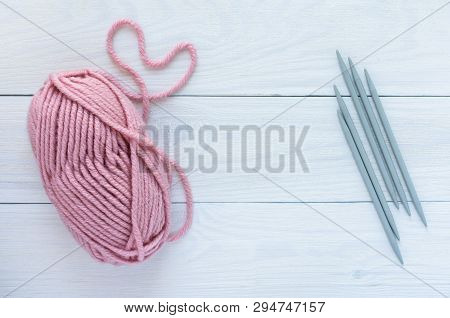Pink Skein With Gray Needles Isolated On White Wooden Background, Knitting Mittens Or Socks On 5 Kni