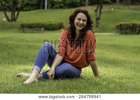 The Pretty Woman In The Park On The Grass