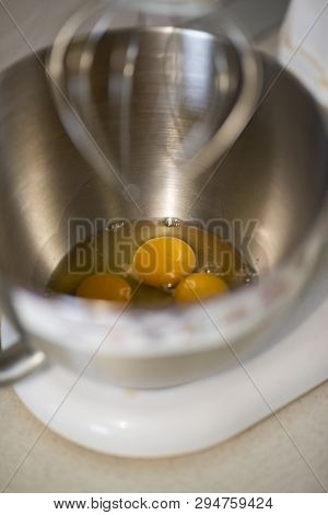 Kitchen Front With Planetary Mixer With Egg Whites And Yolks In A Metalic Bowl Waiting To Be Stirred