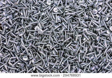 Chrome Self-tapping Screws On The Counter Of A Hardware Store. Background Of The Self-tapping Screws