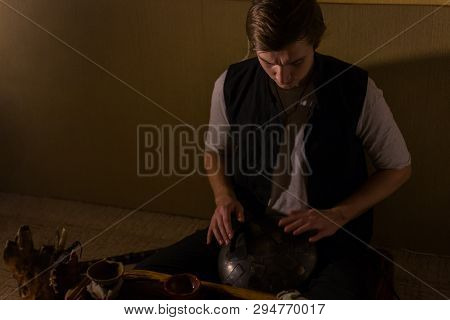 Man Playing Tank Drum Or Hang At Home. Warm Romantic Illumination, Low Key. Relaxation, Meditative A